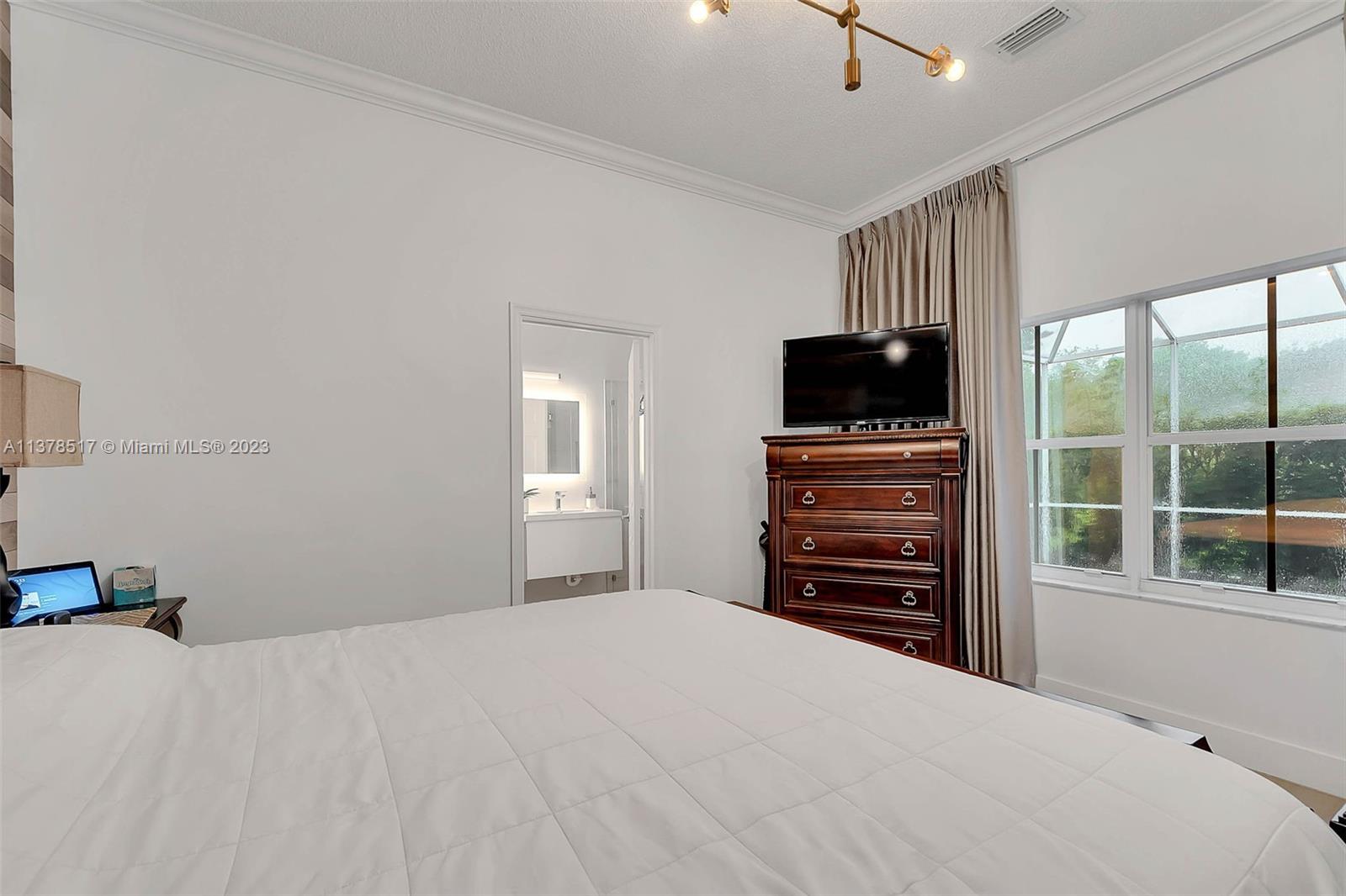 4115 Sabal Ridge Circle Weston, FL 33331 - Photo 23 of 31 a bedroom with a bed and a television