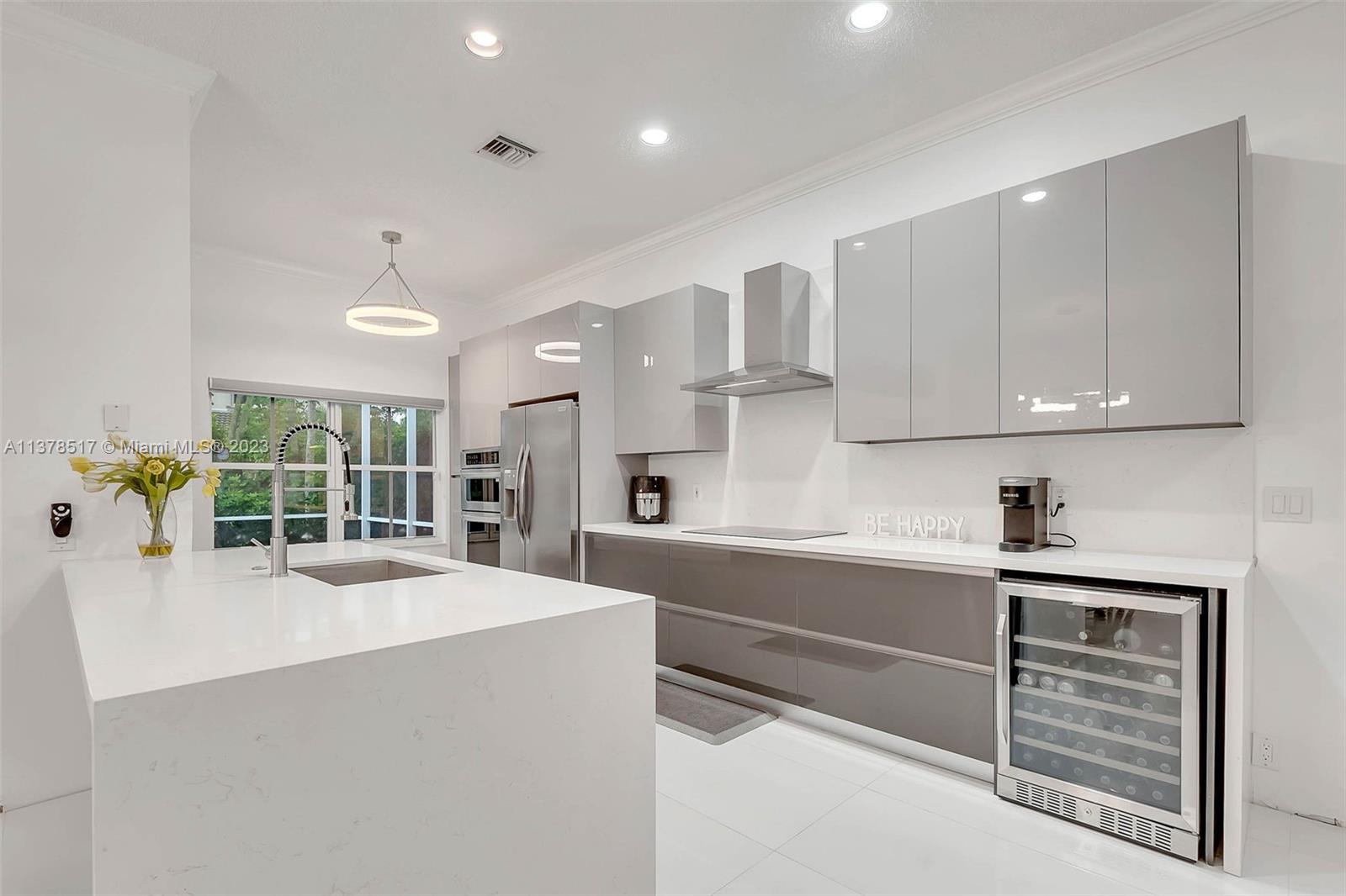 4115 Sabal Ridge Circle Weston, FL 33331 - Photo 3 of 31 a large kitchen with kitchen island a large counter space a sink stainless steel appliances and cabinets