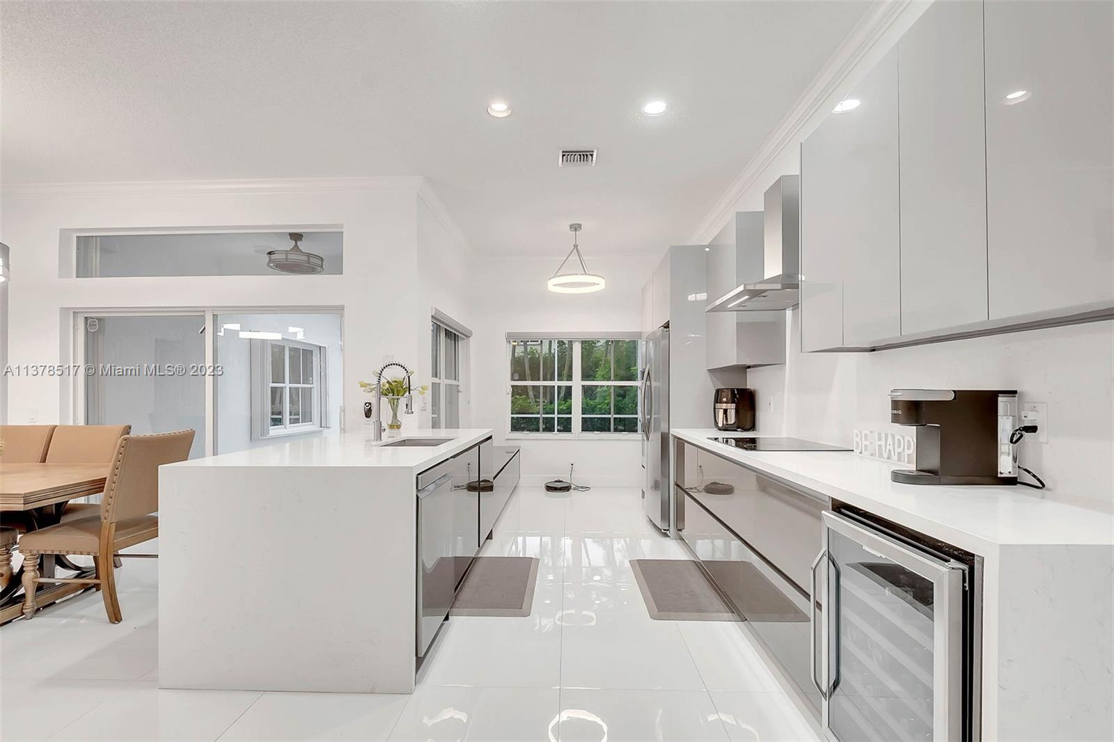 4115 Sabal Ridge Circle Weston, FL 33331 - Photo 4 of 31 a large kitchen with kitchen island a large counter top space a sink stainless steel appliances and cabinets