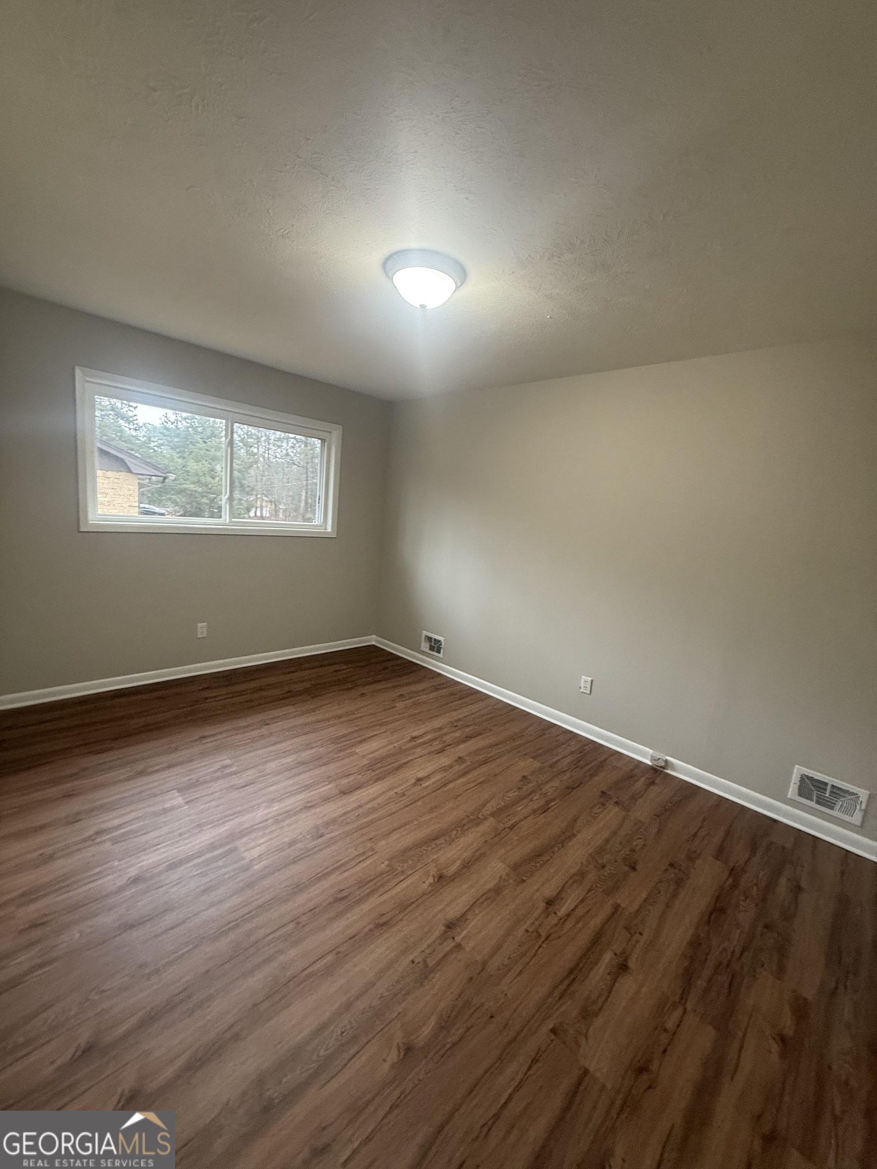 152 Club Circle Stockbridge, GA 30281 - Photo 11 of 17 an empty room with wooden floor and windows
