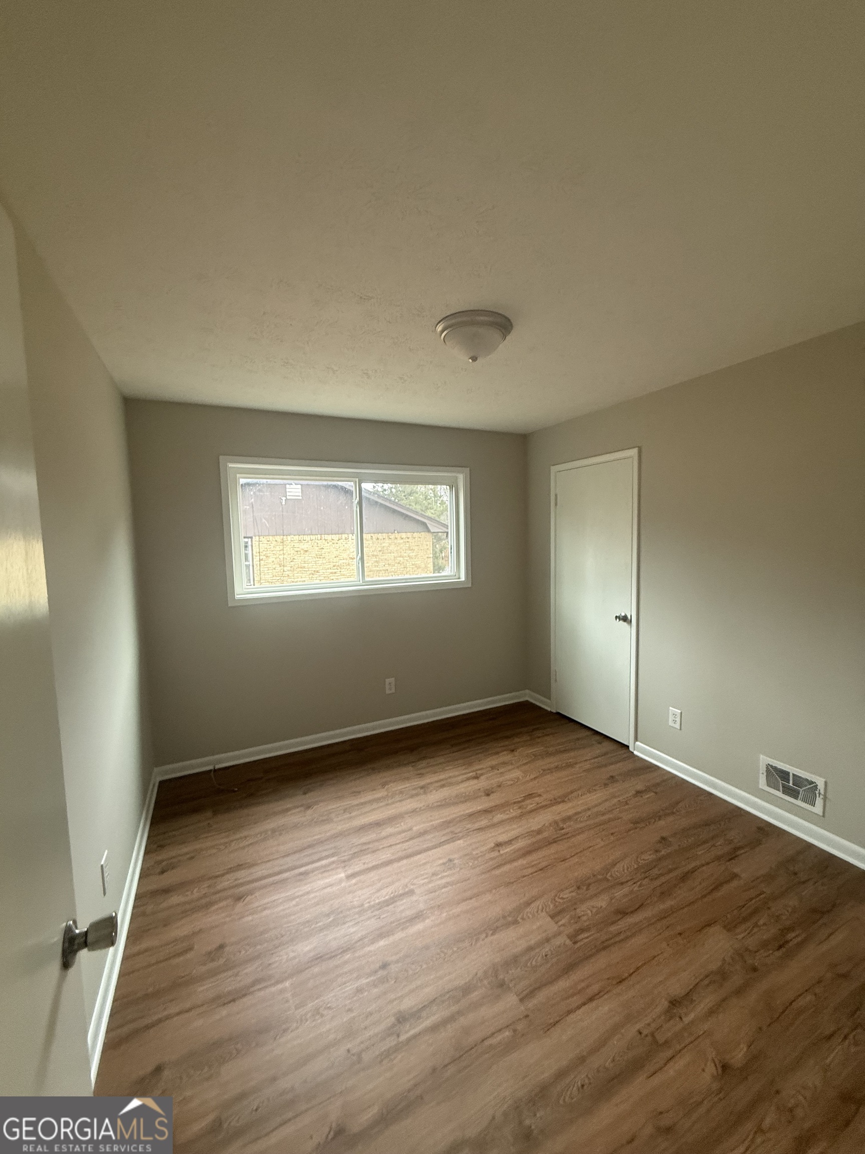 152 Club Circle Stockbridge, GA 30281 - Photo 10 of 17 a view of an empty room with wooden floor and a window