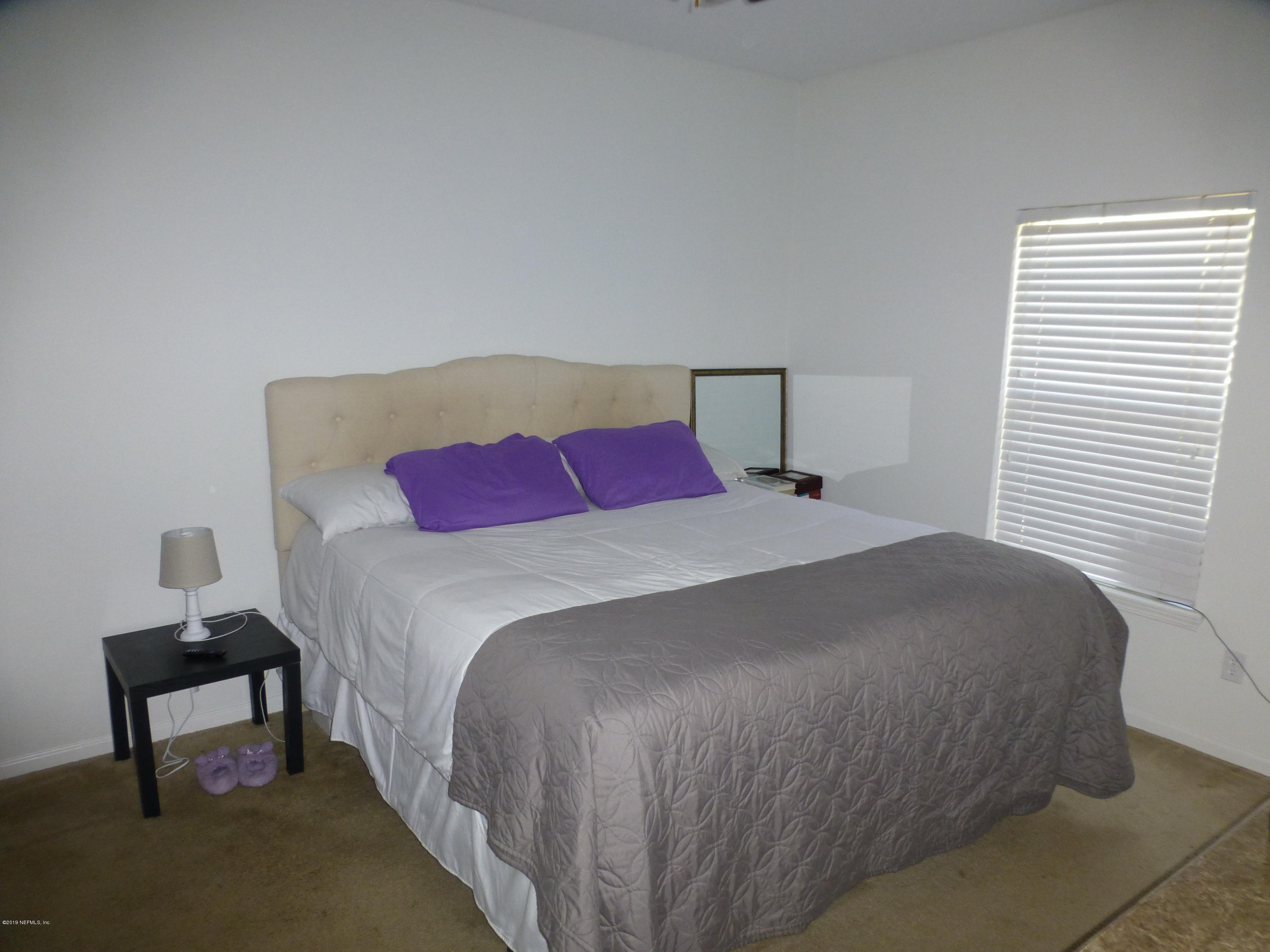 3690 Kirkpatrick Circle, Unit 77 Jacksonville, FL 32210 - Photo 6 of 9 a bedroom with a bed and a lamp