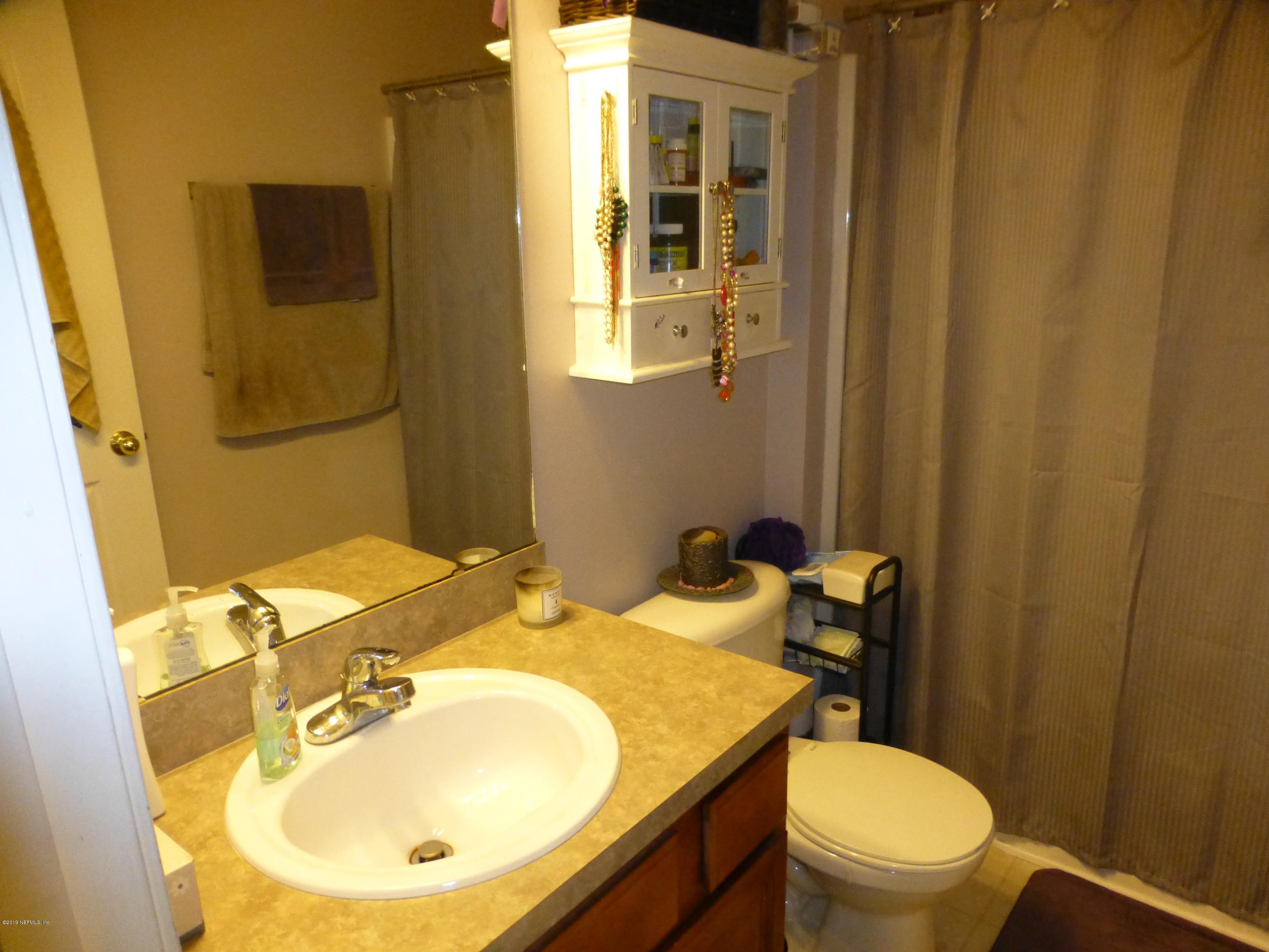 3690 Kirkpatrick Circle, Unit 77 Jacksonville, FL 32210 - Photo 7 of 9 a bathroom with a sink toilet and mirror