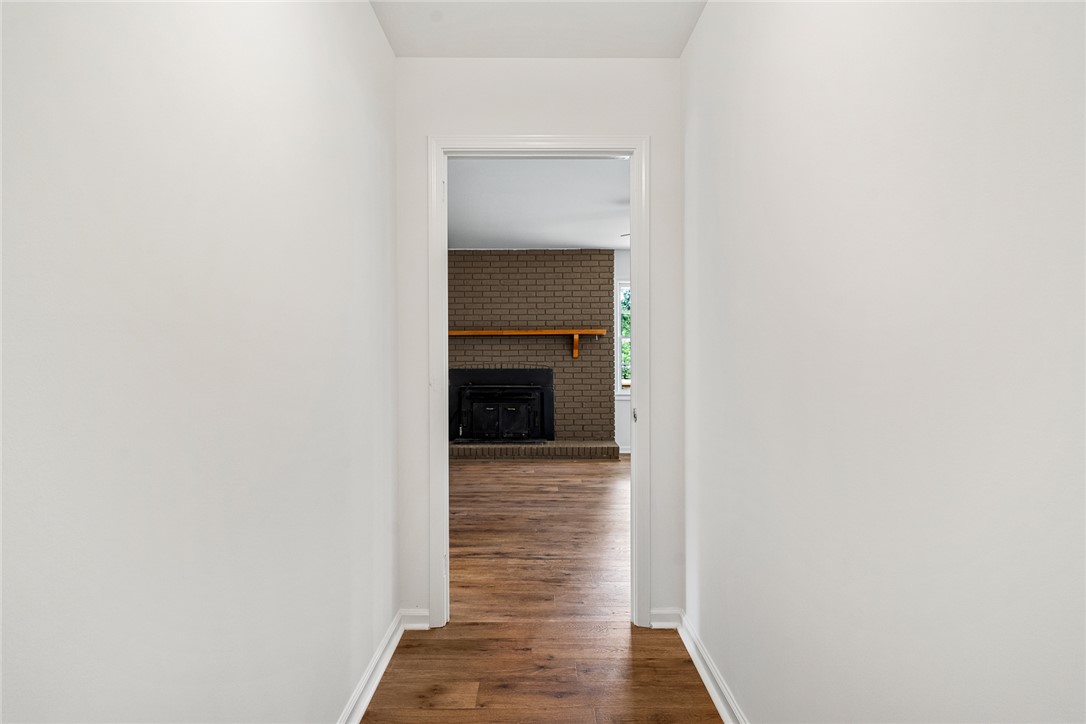300 Vandiver Road Anderson, SC 29621 - Photo 5 of 30 A glimpse into a cozy interior, revealing a brick fireplace and warm wood flooring.