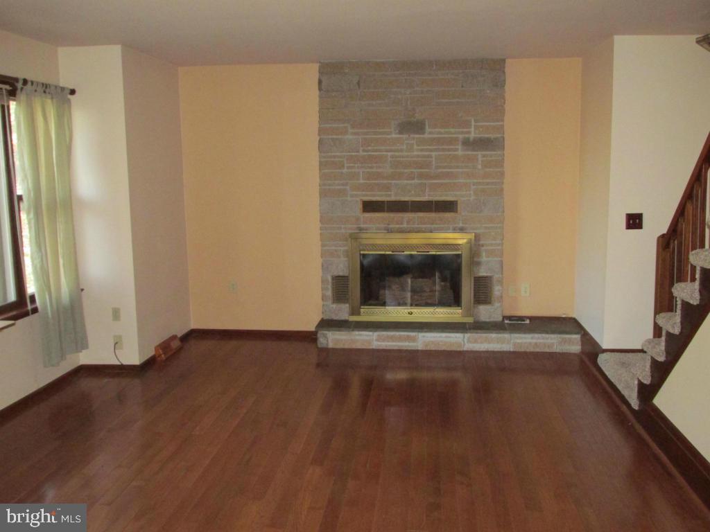 1161 Cider Press Road Manheim, PA 17545 - Photo 4 of 56 a view of empty room with wooden floor and fireplace