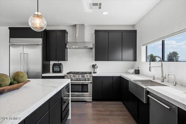 a kitchen with a stove a counter space a sink and living room view