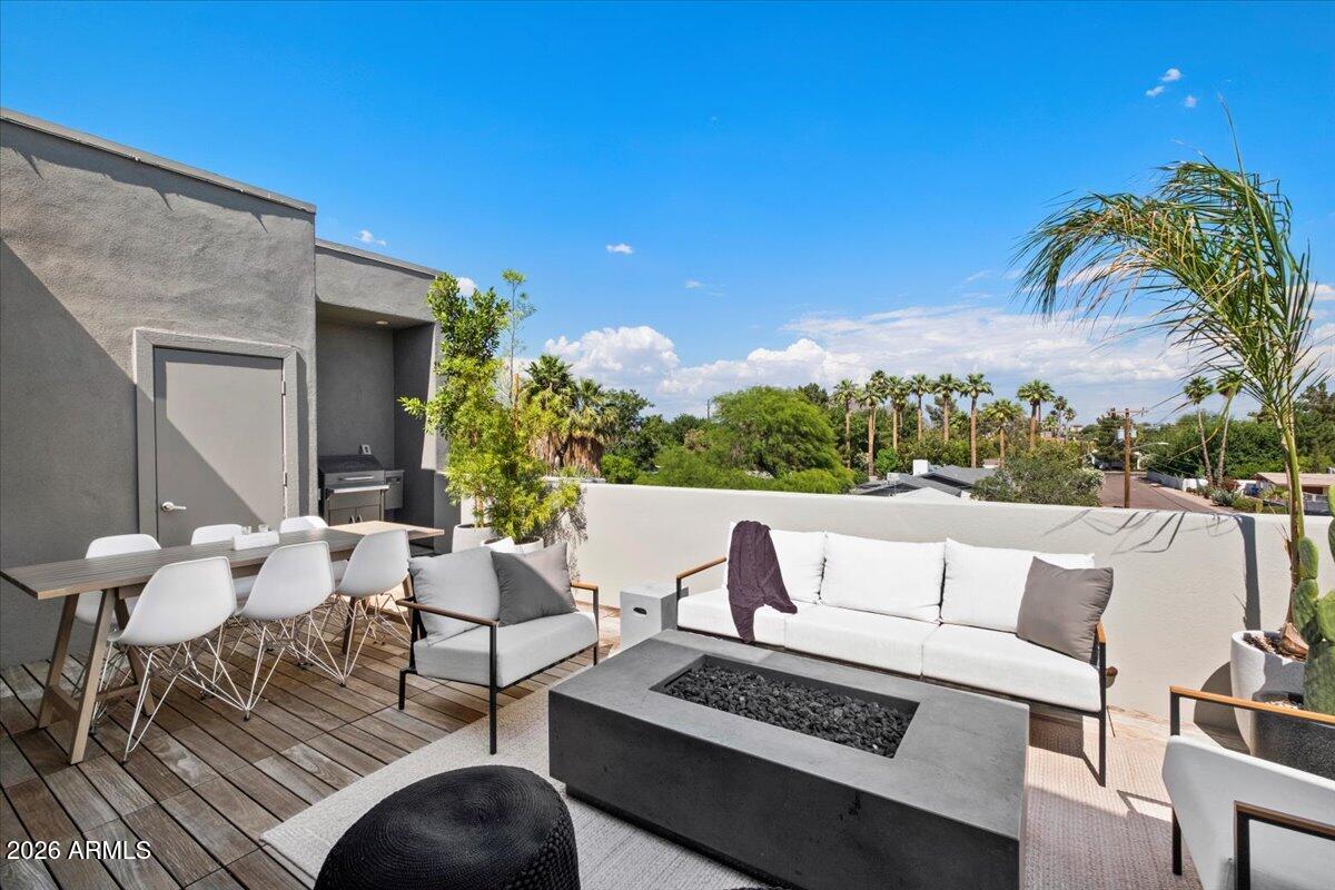 4331 North 27th Place Phoenix, AZ 85016 - Photo 24 of 33 a view of a patio with couches table and chairs with wooden floor and fence