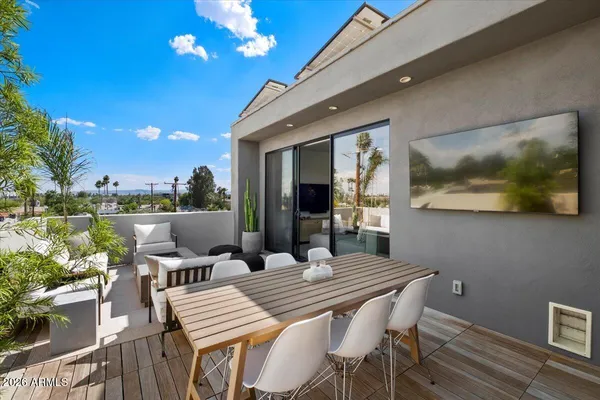 a view of a patio with couches table and chairs with wooden floor and fence
