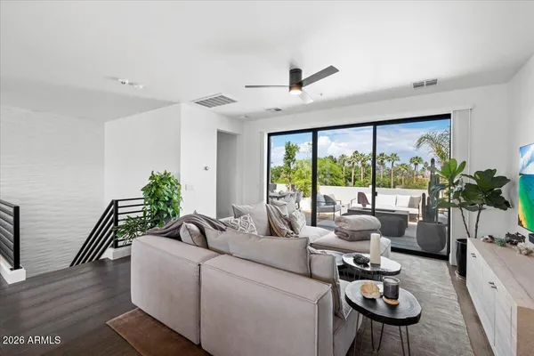 a view of a hallway with wooden floor and stairs