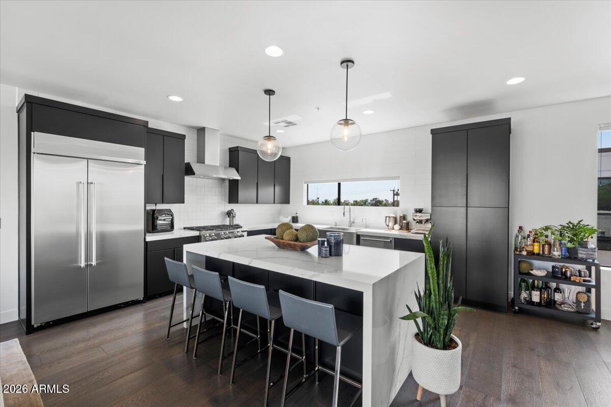 4331 North 27th Place Phoenix, AZ 85016 - Photo 7 of 33 a kitchen with stainless steel appliances a table chairs and a refrigerator