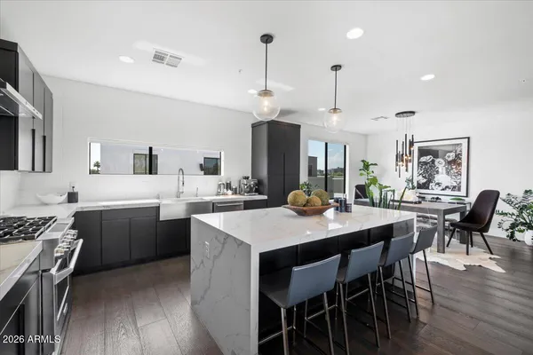 a kitchen with stainless steel appliances a table chairs and a refrigerator