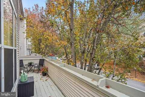 a view of a balcony with wooden floor and fence