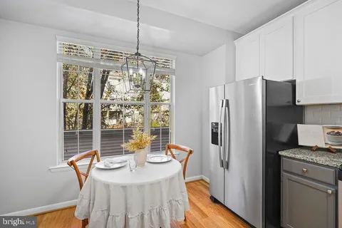 a kitchen with stainless steel appliances granite countertop a refrigerator a stove a sink dishwasher with a dining table and chairs