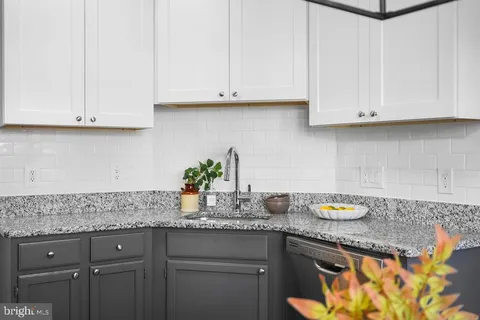 a kitchen with granite countertop white cabinets and a white stainless steel appliances