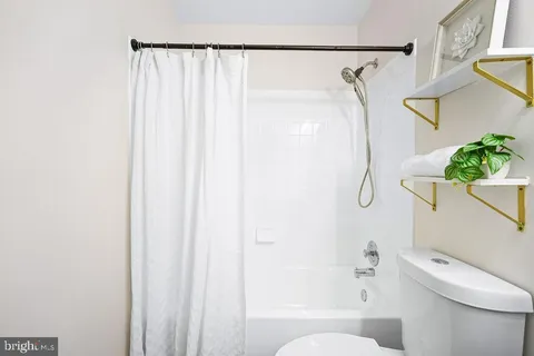 a bathroom with a granite countertop sink mirror vanity and toilet