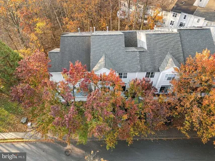 an aerial view of residential house with outdoor space and trees all around