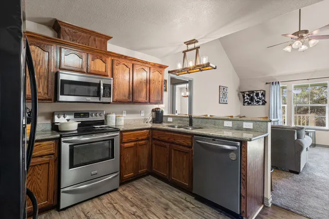 a kitchen with stainless steel appliances granite countertop a sink and stove top oven