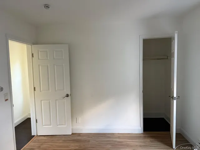 a view of empty room with wooden floor and fireplace