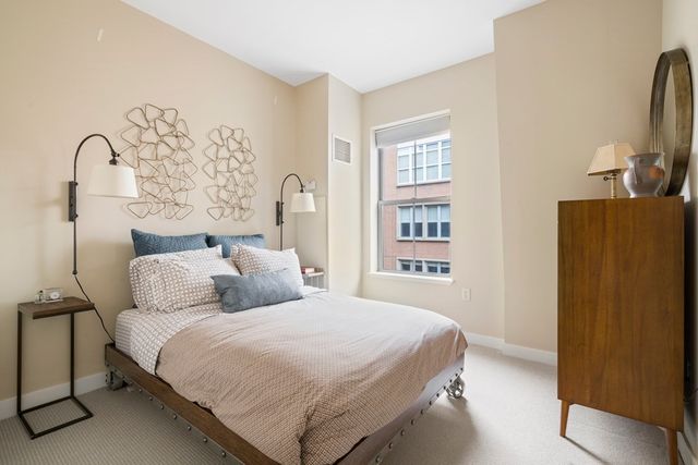 a bedroom with a bed and a flat tv screen on the dresser