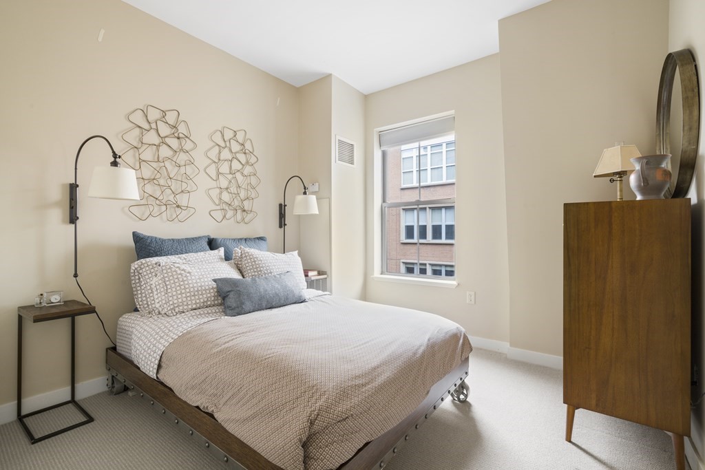 15 Savoy Street, Unit D309 Boston, MA 02118 - Photo 14 of 31 a bedroom with a bed and a flat tv screen on the dresser
