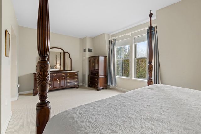 a view of a bedroom with cabinet mirror and windows