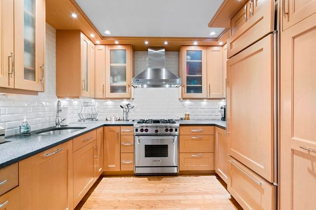 a kitchen with stainless steel appliances granite countertop a stove and a refrigerator