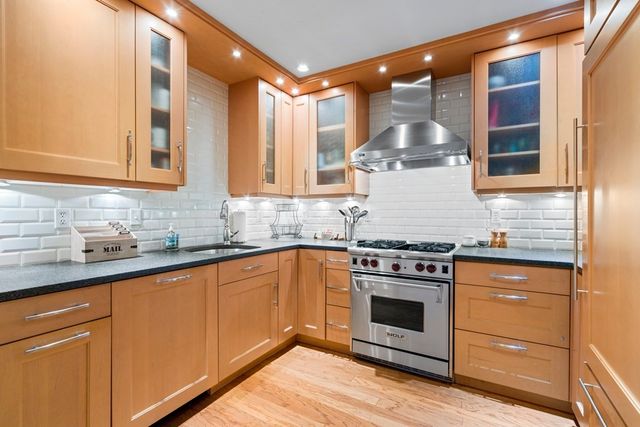 a kitchen with a stove and white cabinets