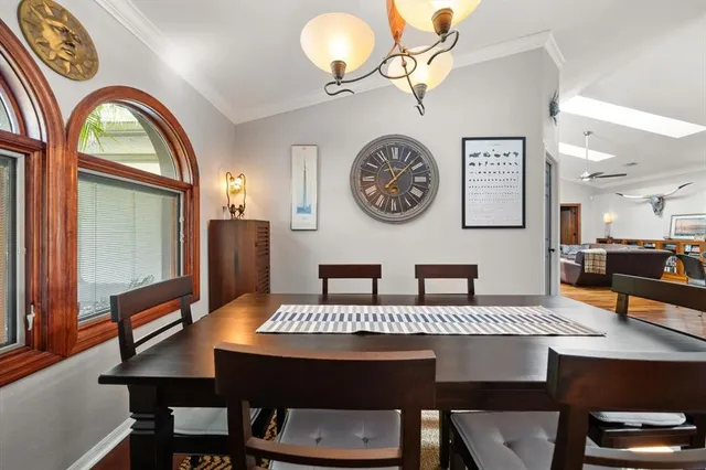 a kitchen island with granite countertop a sink a stove and a dining table with wooden floor