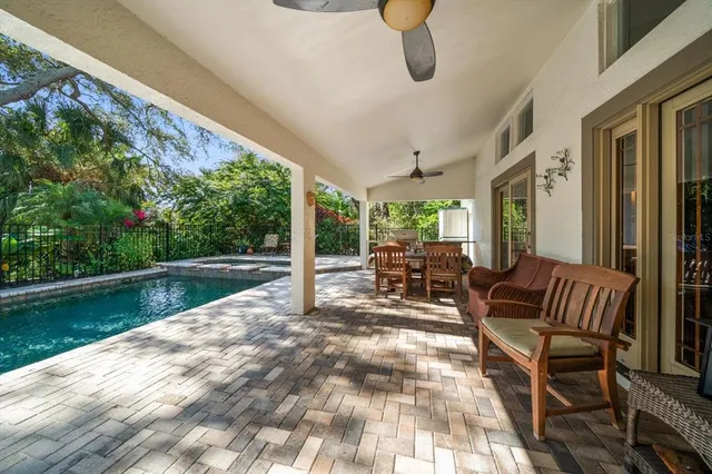 a view of a patio with a dining table and chairs with wooden floor and fence