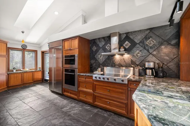 a kitchen with stainless steel appliances kitchen island granite countertop a stove and cabinets
