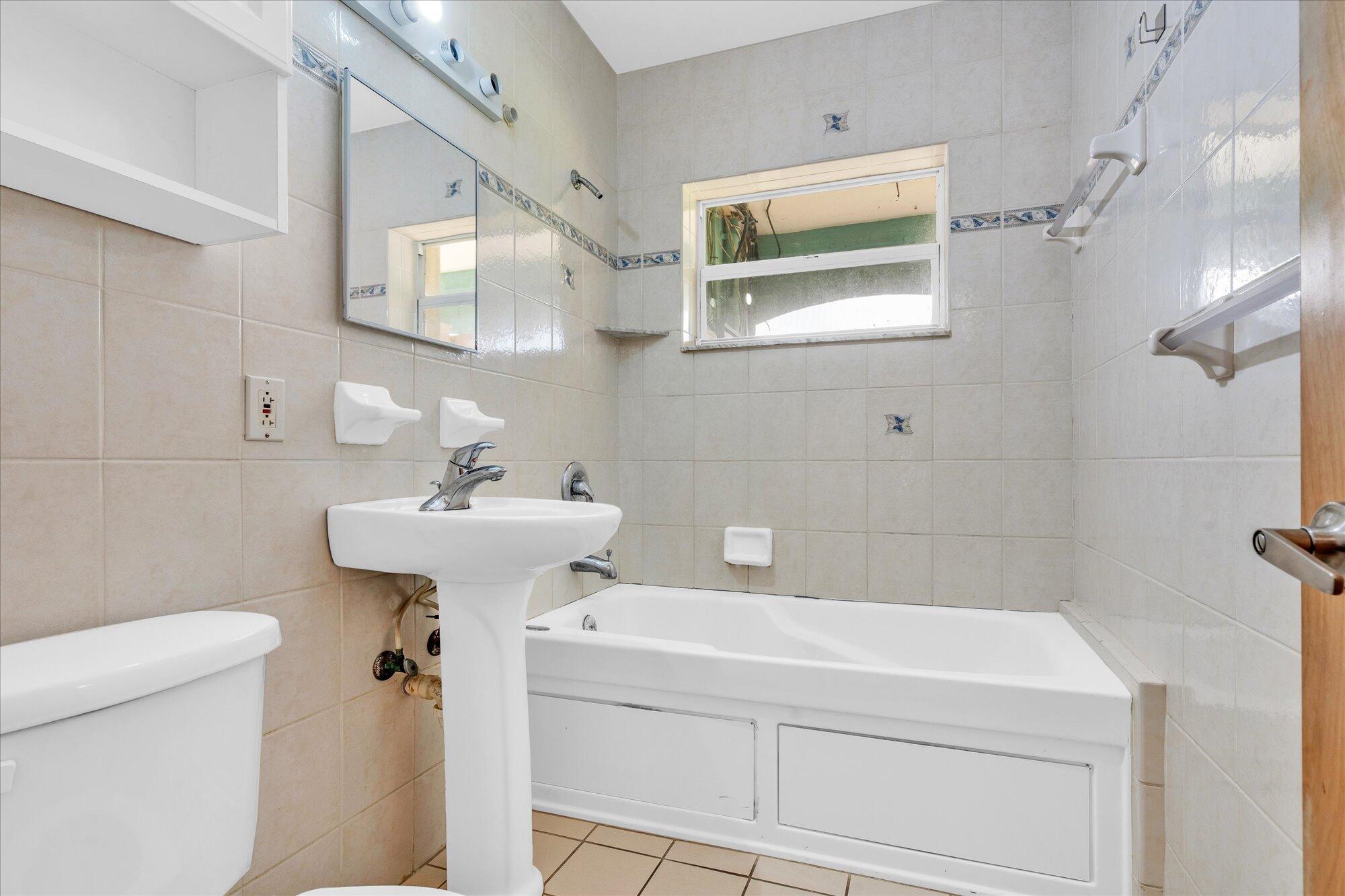 7984 Tuna Drive Marathon, FL 33050 - Photo 15 of 40 a bathroom with a sink a toilet and mirror