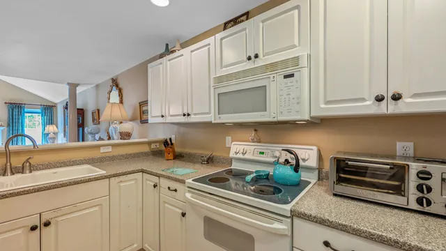 a kitchen with stainless steel appliances granite countertop a stove a sink dishwasher and a refrigerator with wooden floor