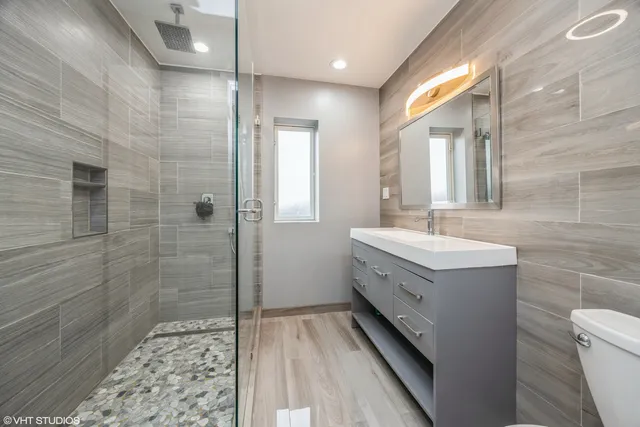 a bathroom with a double vanity sink toilet and shower