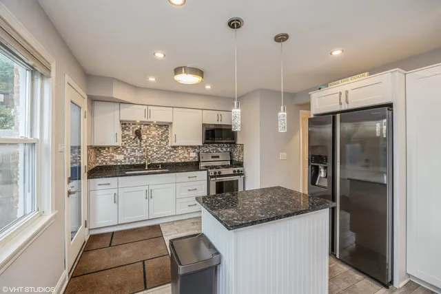 a kitchen with stainless steel appliances granite countertop a stove and a refrigerator