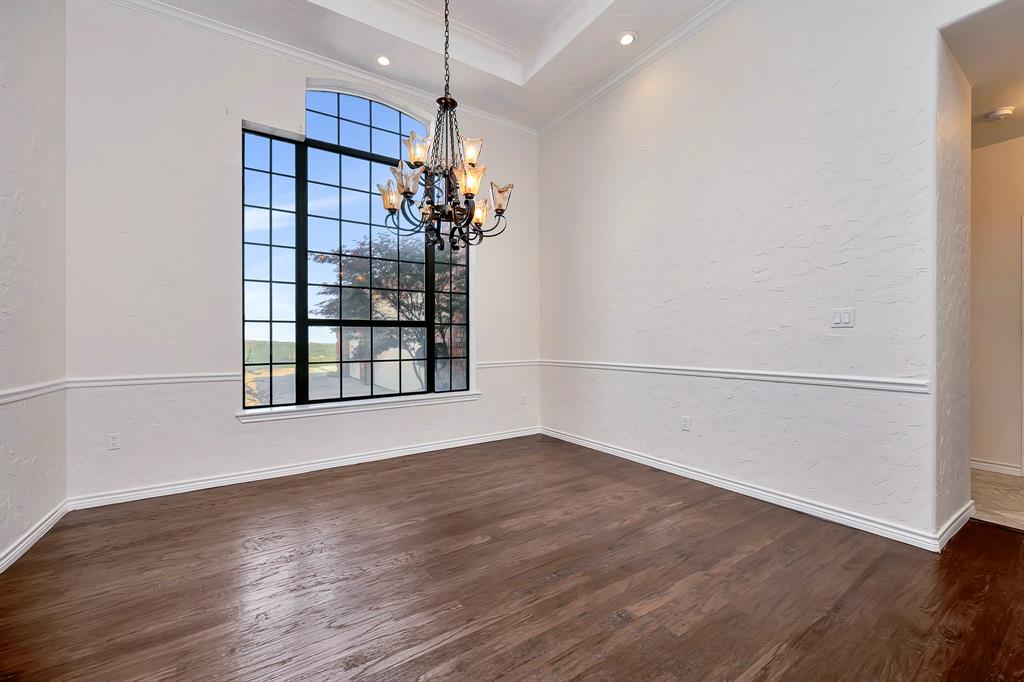 5520 White Settlement Road Weatherford, TX 76087 - Photo 17 of 40 an empty room with wooden floor chandelier and windows