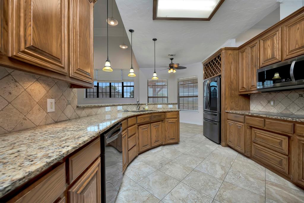 5520 White Settlement Road Weatherford, TX 76087 - Photo 19 of 40 a kitchen with stainless steel appliances granite countertop a sink stove and cabinets