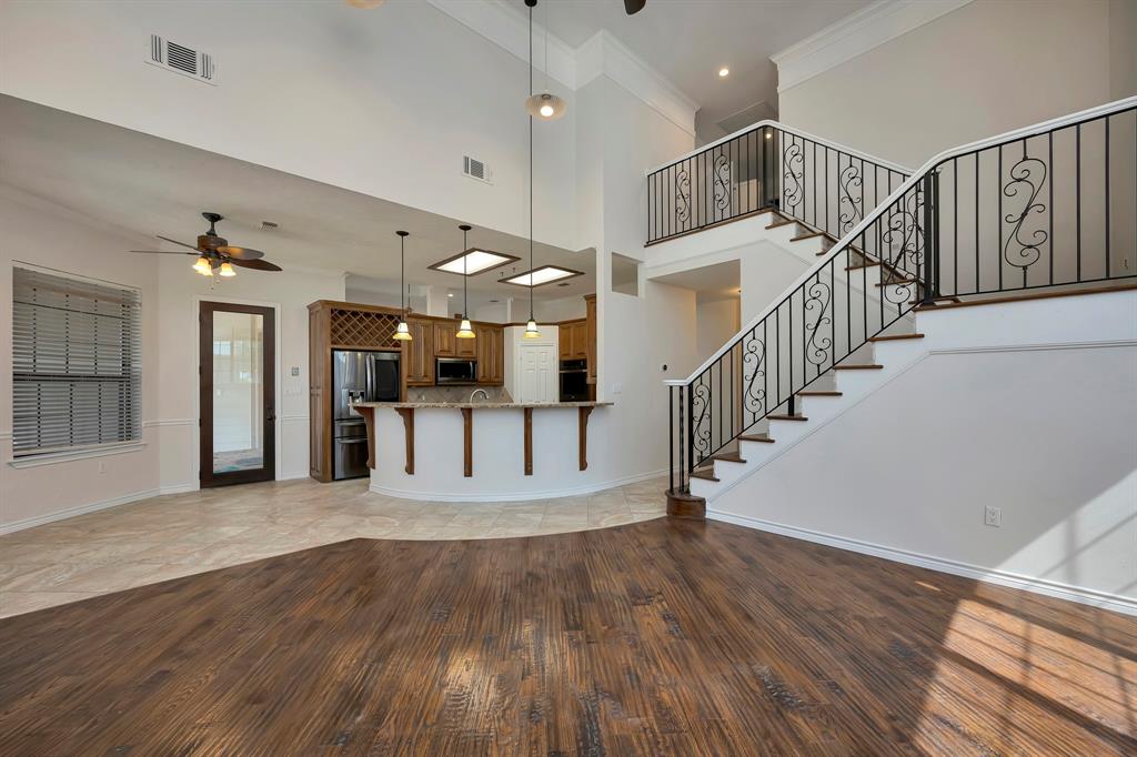 5520 White Settlement Road Weatherford, TX 76087 - Photo 26 of 40 a view of staircase and kitchen with wooden floor
