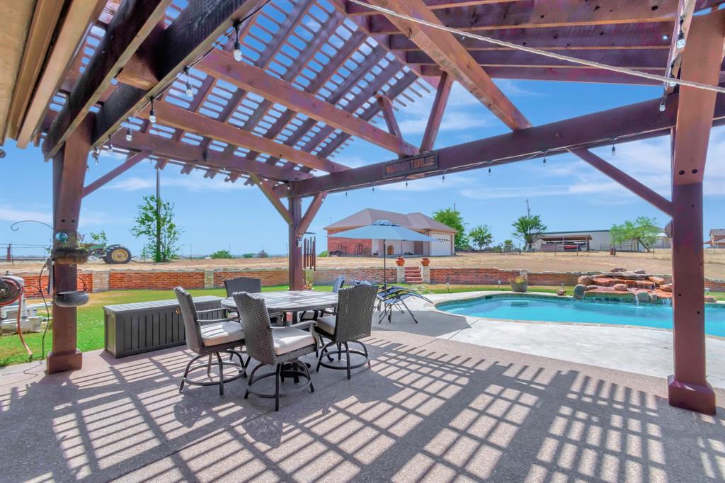 5520 White Settlement Road Weatherford, TX 76087 - Photo 5 of 40 a view of a patio with table and chairs barbeque potted plants and large tree
