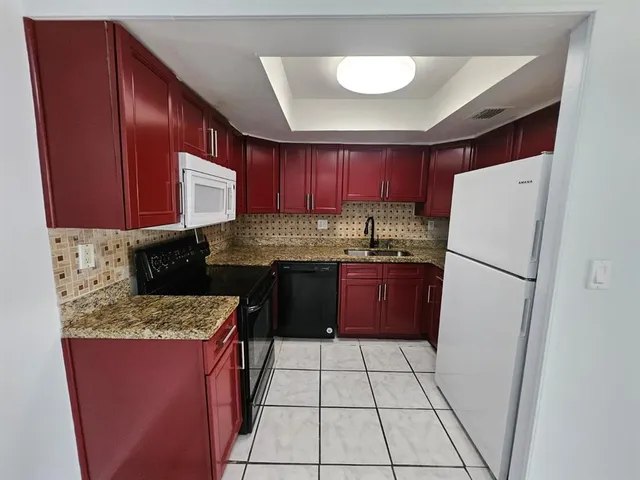 a kitchen with stainless steel appliances granite countertop a refrigerator stove a sink and dishwasher