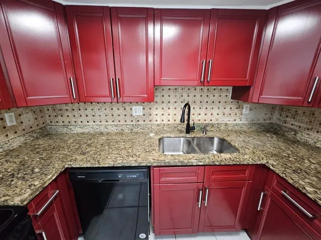 a kitchen with granite countertop cabinets and black stainless steel appliances