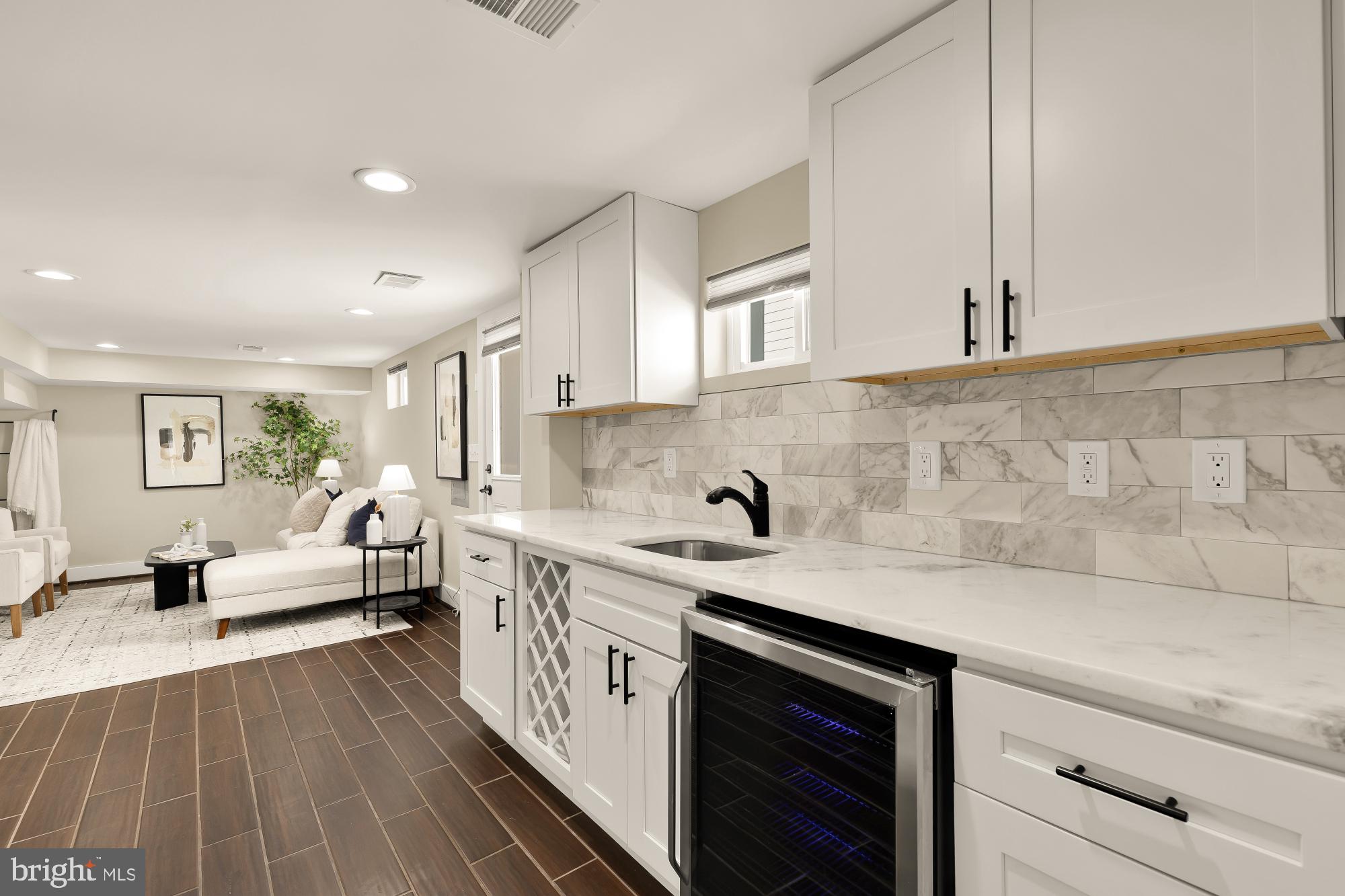 6519 Piney Branch Road Northwest Washington, DC 20012 - Photo 39 of 47 a kitchen with a sink dishwasher stove and white cabinets with wooden floor