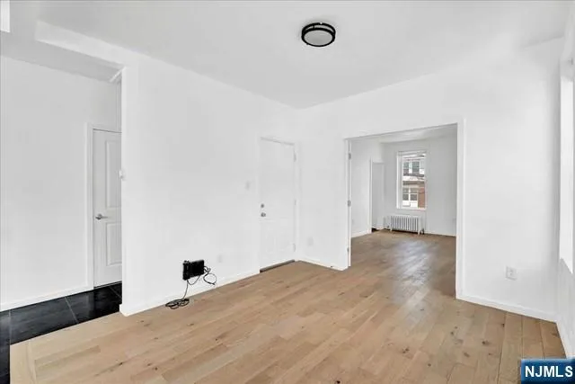 a view of a livingroom with wooden floor and a ceiling fan