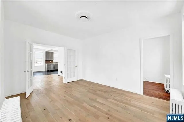 a view of empty room with wooden floor