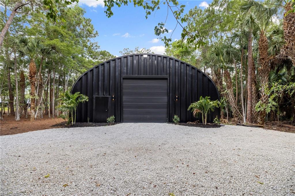 4521 3rd Avenue Northwest Naples, FL 34119 - Photo 41 of 46 a view of a house with a yard and garage