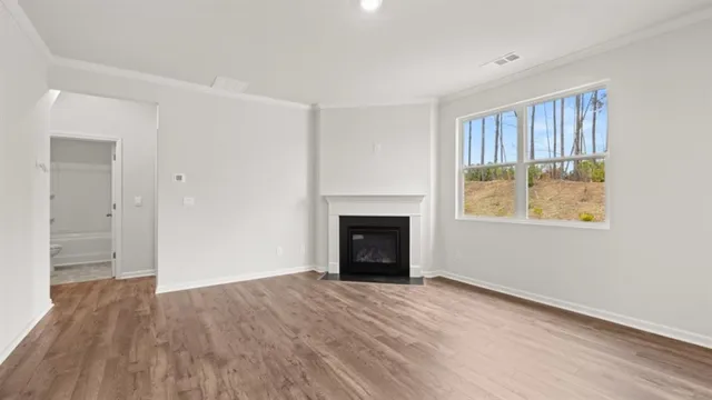 wooden floor fireplace and windows in an empty room