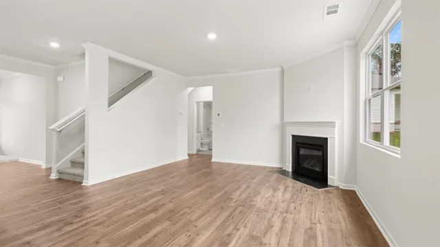 a view of empty room with wooden floor and fireplace