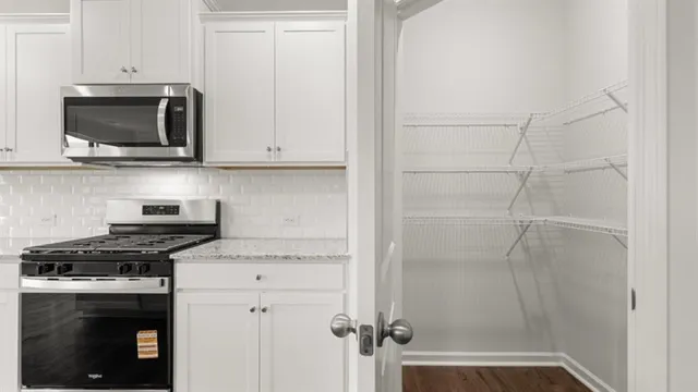 a kitchen with white cabinets and stainless steel appliances