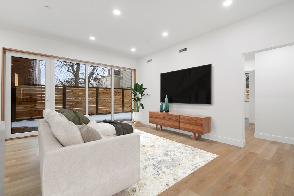 3171 Washington Street, Unit 101 Boston, MA 02130 - Photo 3 of 10 a living room with furniture and a flat screen tv