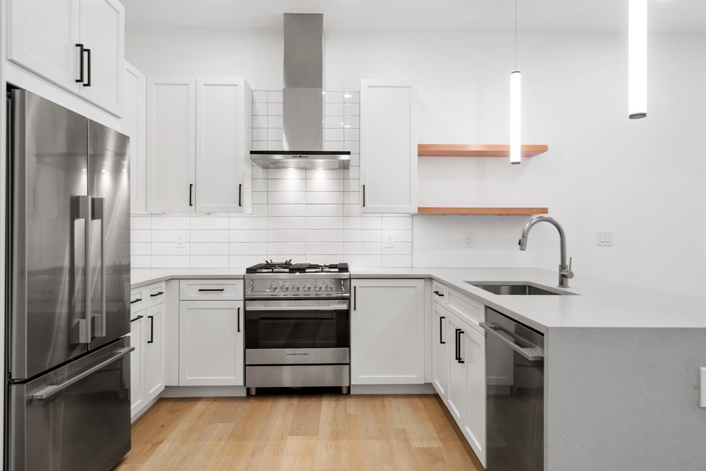 3171 Washington Street, Unit 101 Boston, MA 02130 - Photo 4 of 10 a kitchen with stainless steel appliances granite countertop a sink stove and refrigerator