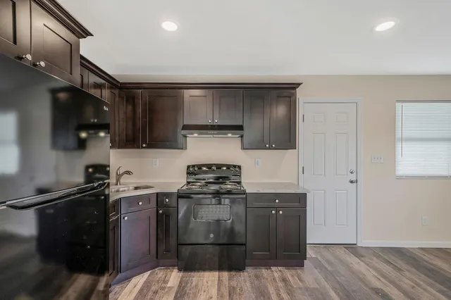 a kitchen with stainless steel appliances granite countertop a stove a sink and a refrigerator